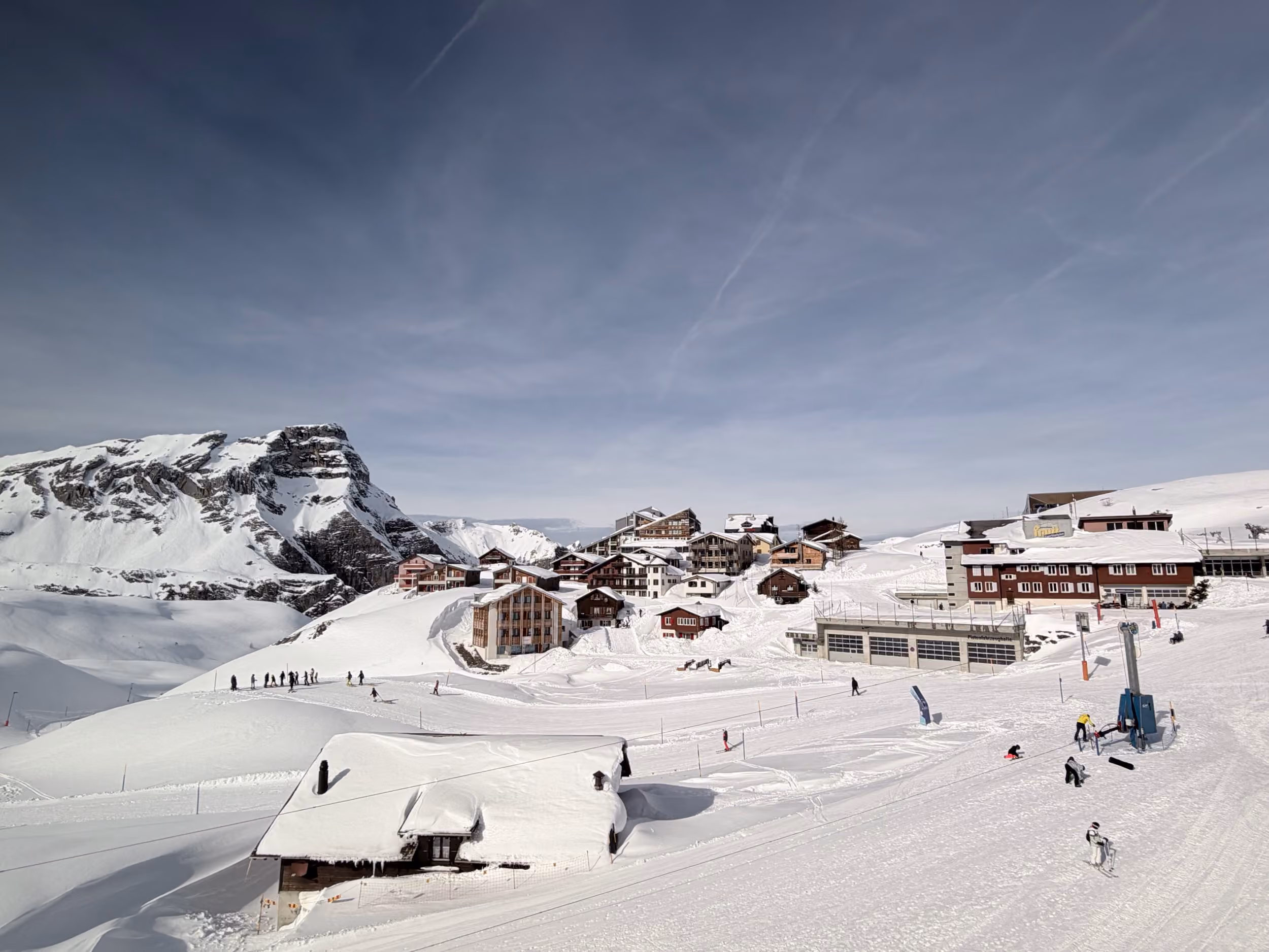 Das tief verschneite Frutt-Dorf mit Holzhäusern und Skifahrern