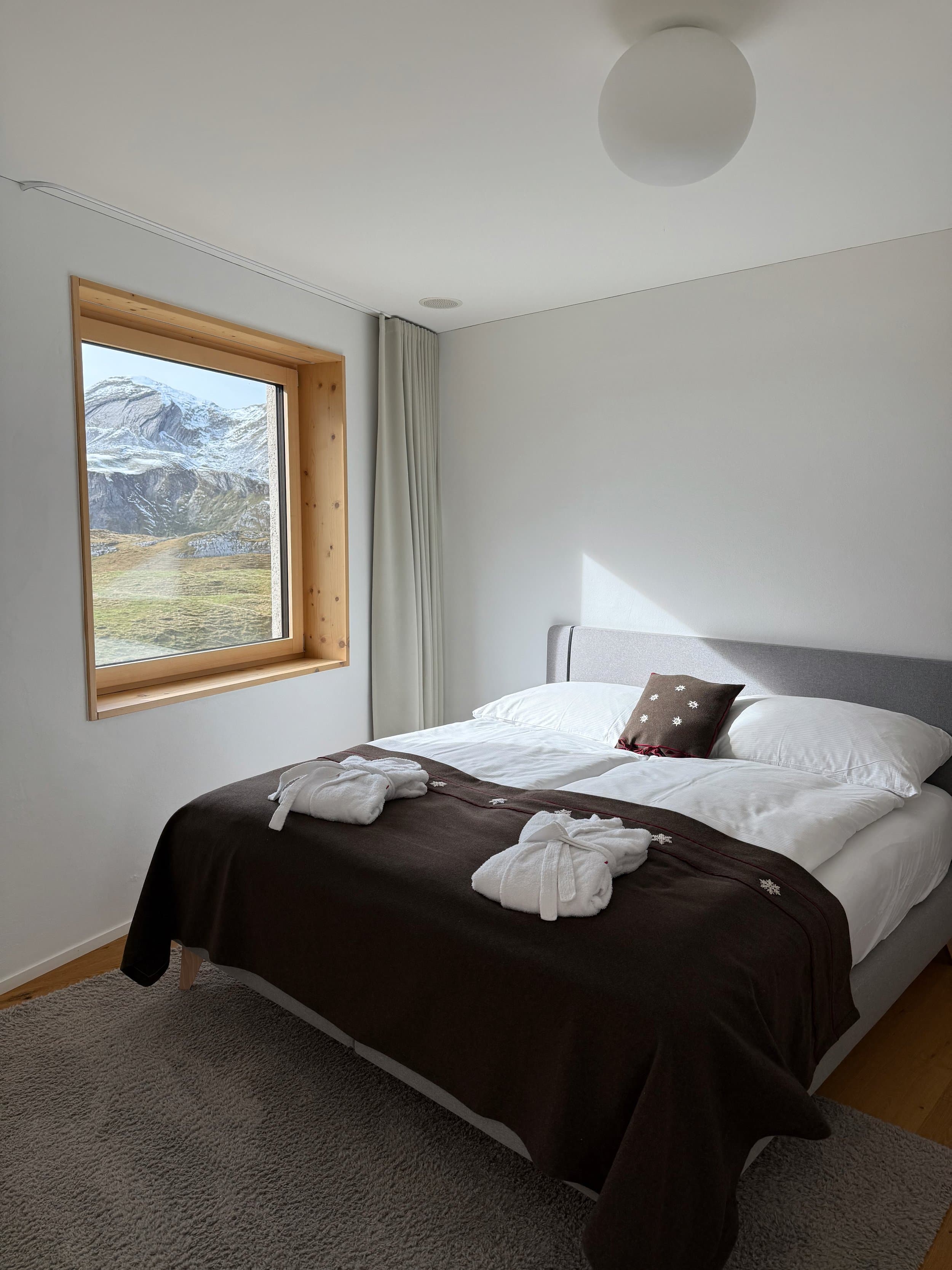 Schlafzimmer mit Boxspring-Doppelbett und Bademänteln