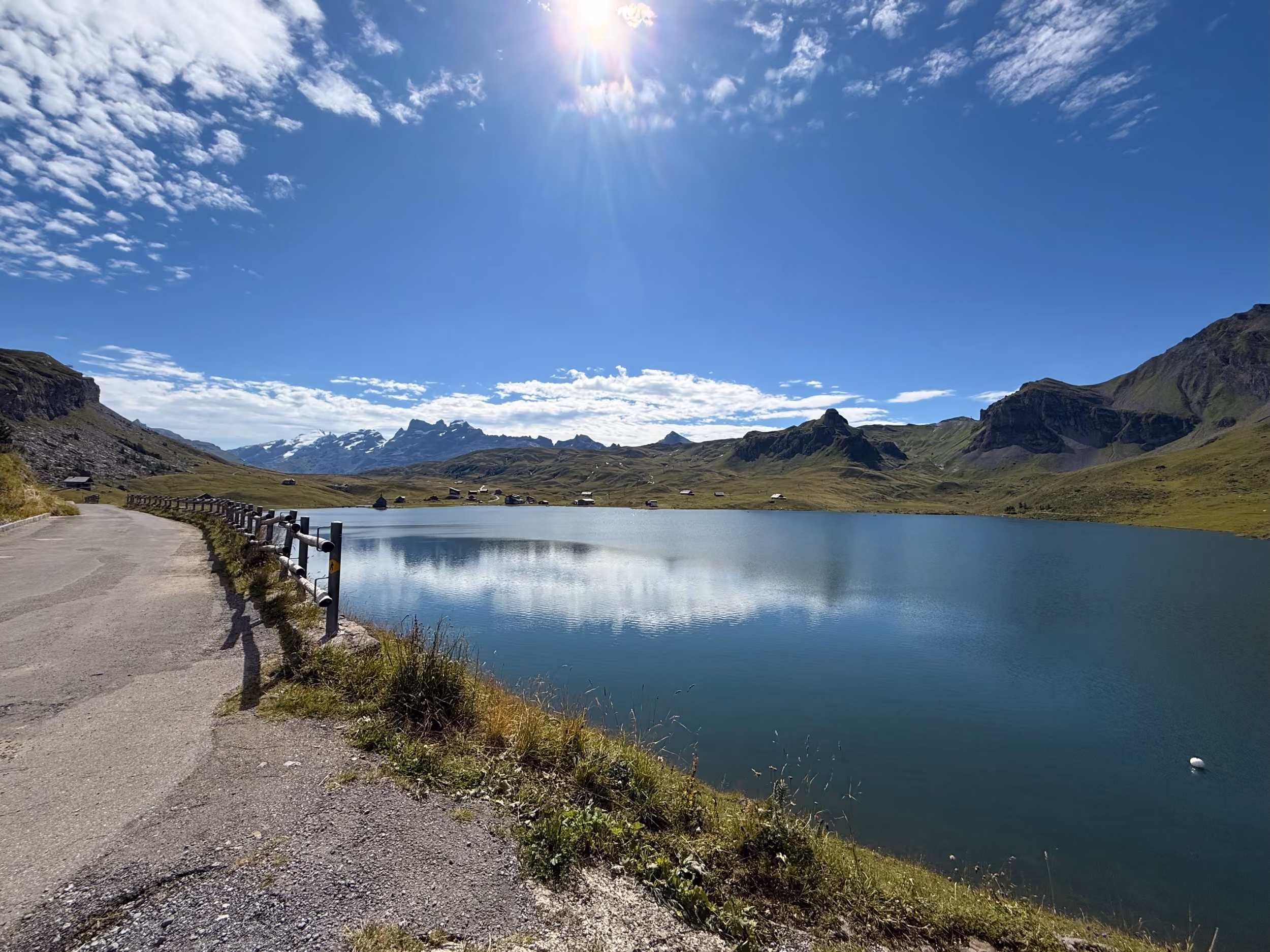 Uferweg am Melchsee mit Blick über das Wasser zu den Alphütten und Gipfeln