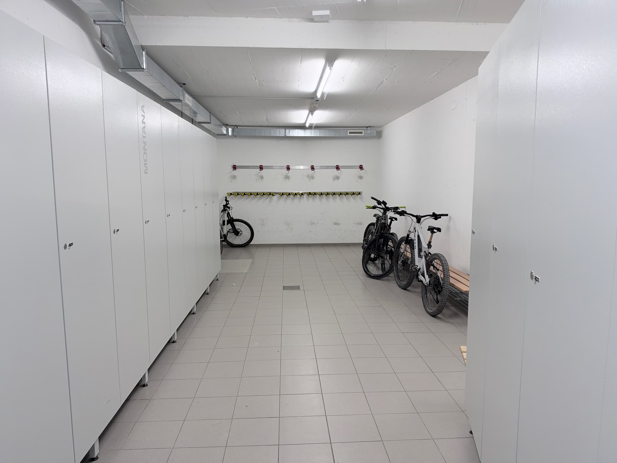 Skiraum mit Kästen, Bank und abgestellten Velos