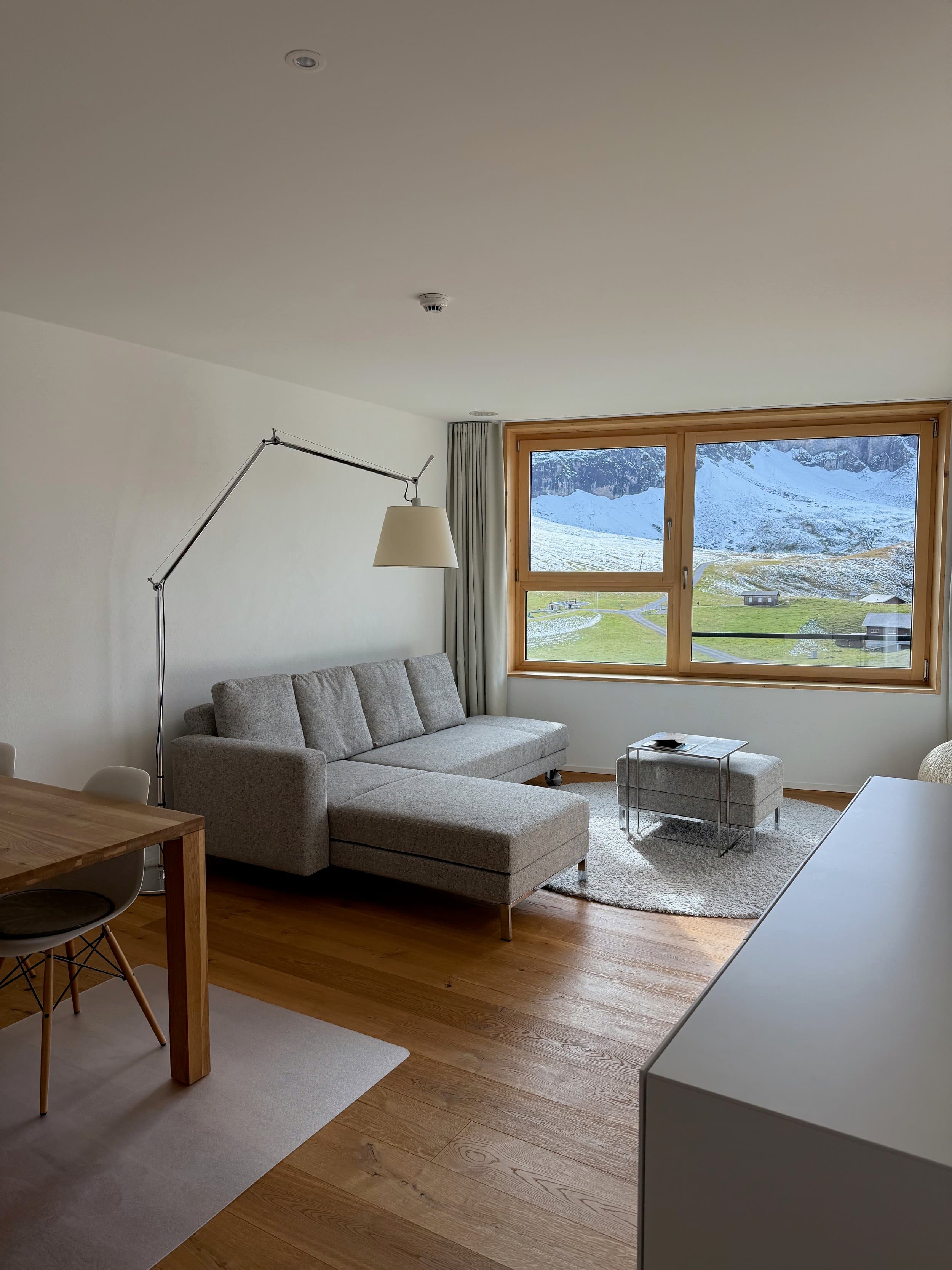 Wohnbereich mit Ecksofa und Fenster mit Blick in die Berge