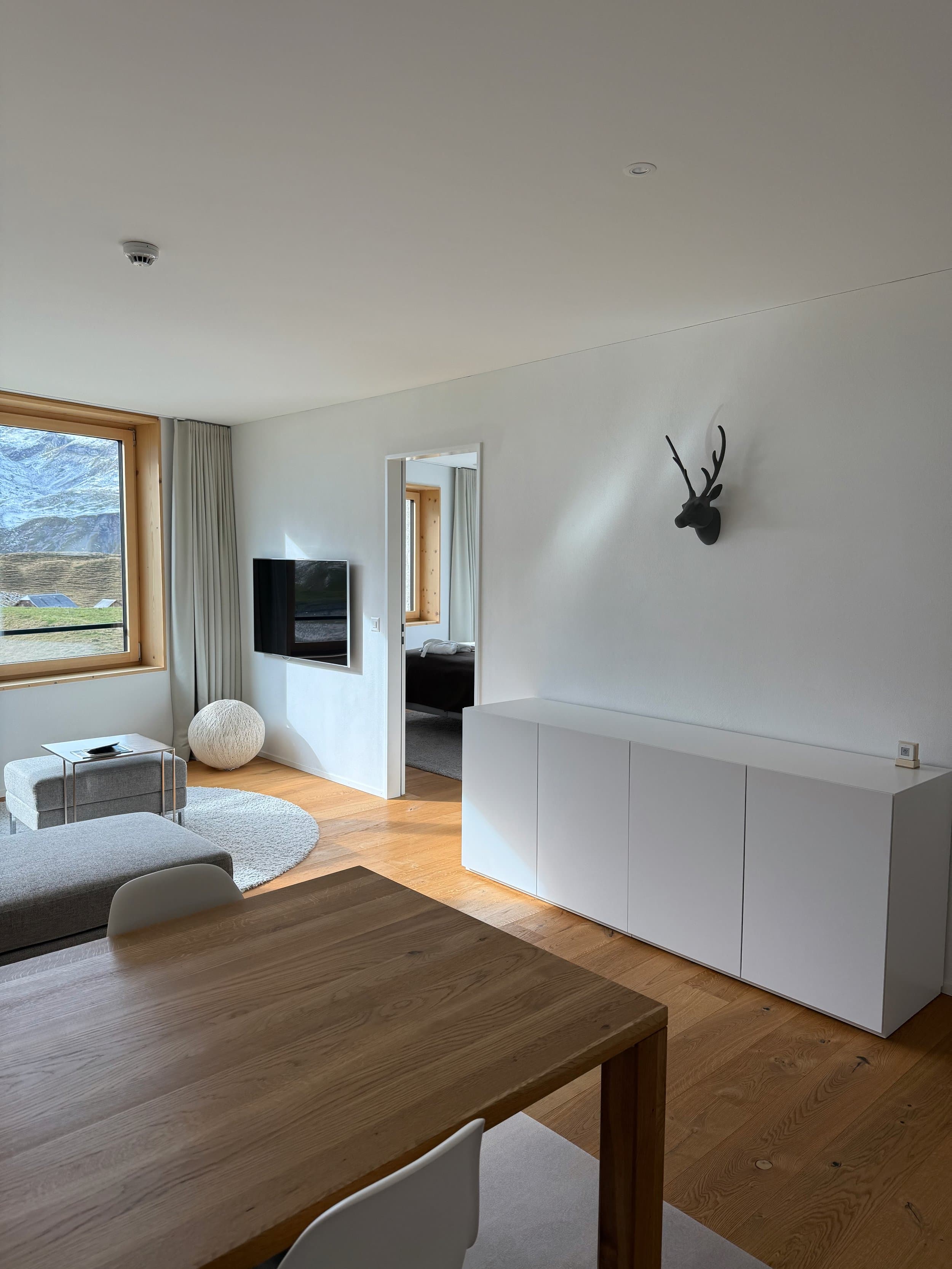 Wohnbereich der Ferienwohnung mit Sideboard, Fernseher und Esstisch